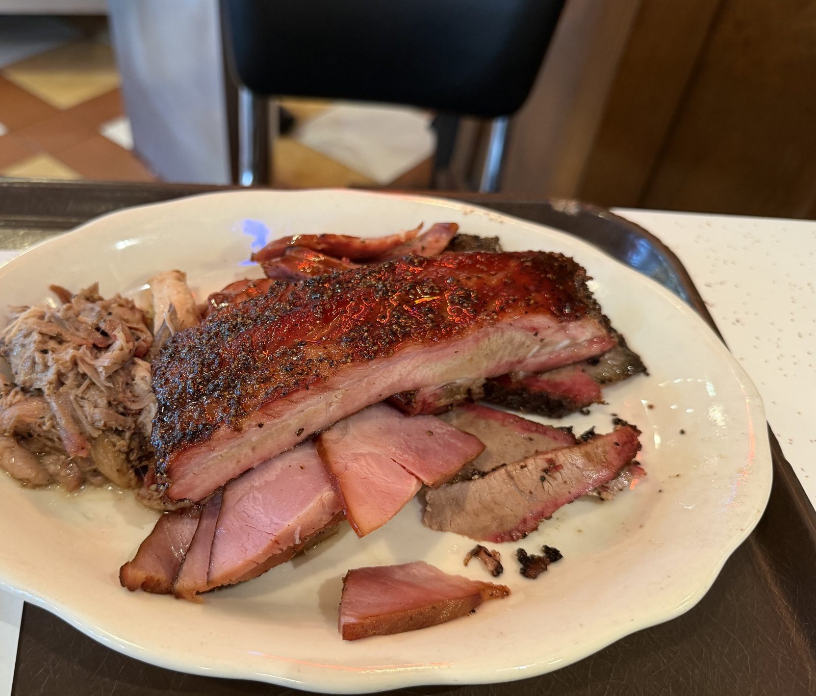 A plate of Houston barbecue: brisket, ribs, ham, and pulled pork